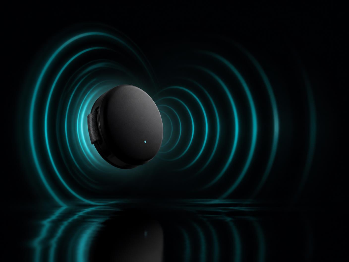 A matte-black wearable sensor emitting concentric teal signal rings